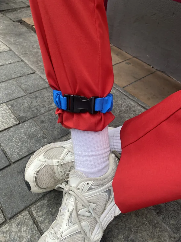 A Royal Blue strap gathering red trousers above a white trainer